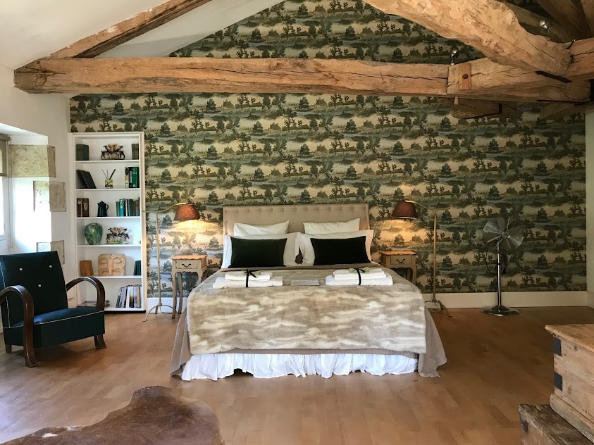 The Brook bedroom with decorative wallpaper and fur throw