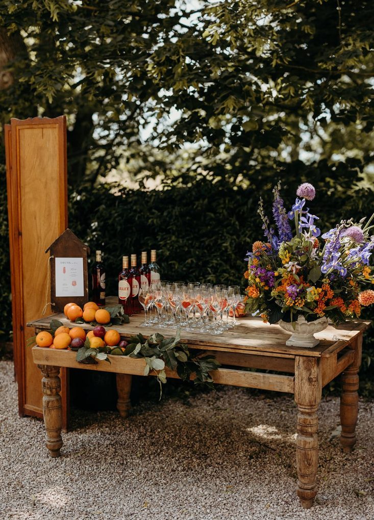 Bar set up for the reception guests arrival, with glasses prepared for Lillet Rosé and a stunning floral arrangement.